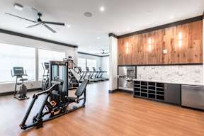 A gym with a row of treadmills and a weight machine.