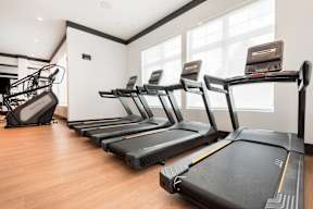 A gym with treadmills and a treadmill in the foreground.