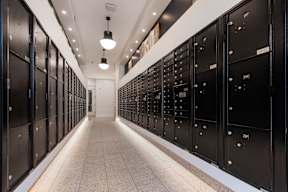 A long hallway with black lockers on both sides.