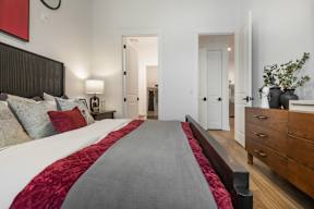 A bedroom with a large bed and a red headboard.