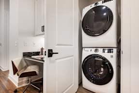 A white washing machine is in a small laundry room.