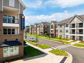A view of a street with apartment buildings on both sides.