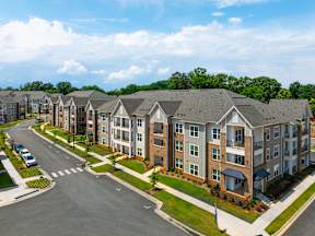 A row of modern apartment buildings are shown from an aerial perspective.