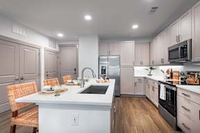 A modern kitchen with a dining table set for two.