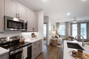 A modern kitchen with a black stove top oven and a black microwave above it.