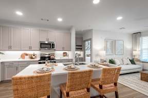 A modern kitchen with a dining table set for two.