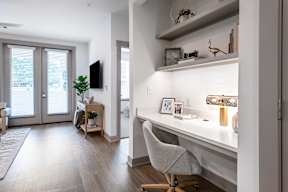 A white desk with a chair and a plant on it.