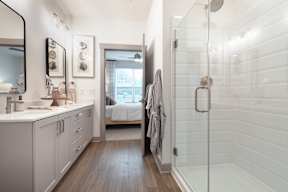 A bathroom with a walk in shower and a vanity.