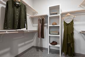 A white shelf with a green dress hanging on it.