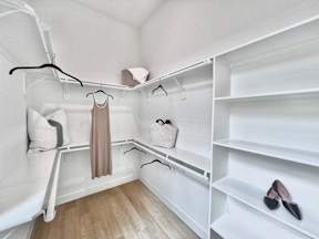 A closet with a white shelving unit and a pair of black shoes on the shelf.