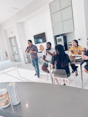 a group of people in a kitchen talking and eating