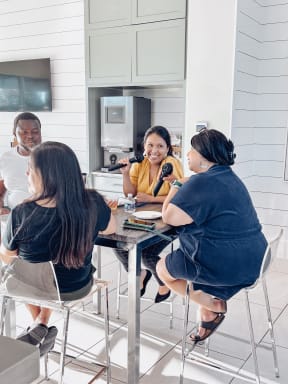 a group of people sitting around a kitchen table talking