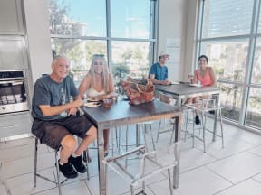 a group of people sitting at a table in a room with large windows