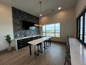 A modern kitchen with a large island and a dining table.