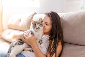a woman laying on a couch with a cat