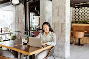 a woman sitting at a table with a laptop