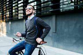 a man riding a bike while holding a cell phone