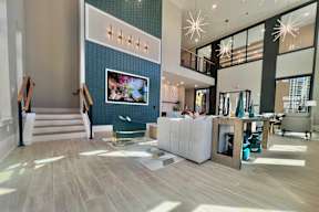 A spacious lobby with a staircase, a couch, and a television.
