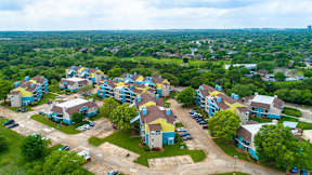 A bird's eye view of a residential area with houses and cars.
