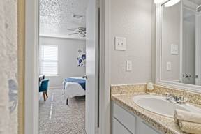A bathroom with a blue bed in the background.