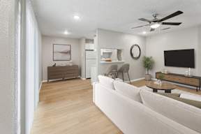 A modern living room with a white sofa and a wooden floor.