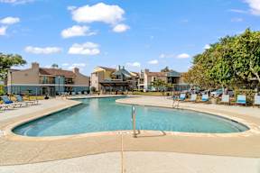 A large swimming pool in front of a resort.