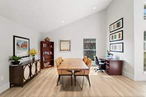 A dining room with a wooden table and chairs.