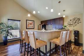 A kitchen with a bar area and chairs.