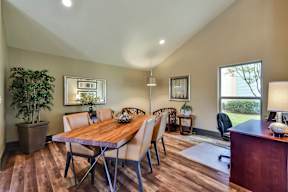 A dining room with a wooden table and chairs.