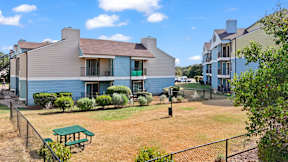 A blue house with a green picnic table in front.