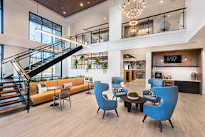 A modern living room with blue chairs and a wooden floor.