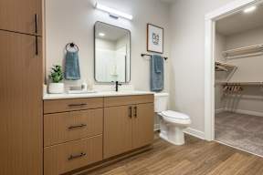 A bathroom with a wooden vanity and a white toilet.