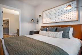 A bedroom with a bed, nightstands, and a lamp.