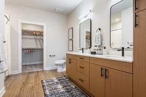 A bathroom with a toilet, sink, and mirror.