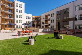 A sunny day at a modern apartment complex with a grassy courtyard.