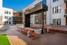 A modern building with a wooden deck and rocking chairs.