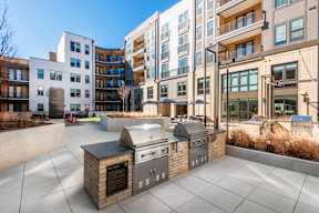 A modern outdoor kitchen area with a grill and a barbecue oven.