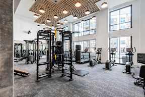 A gym with a variety of equipment including treadmills, stationary bikes, and weight machines.