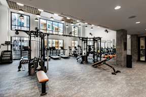A gym with a variety of equipment including weights and benches.
