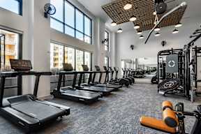 A gym with treadmills, weights, and exercise equipment.