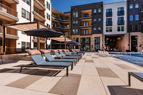A sunny day at the pool with lounge chairs and umbrellas.
