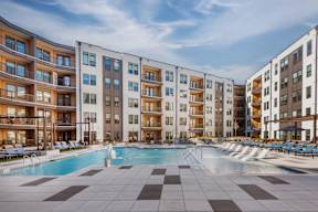 A large swimming pool in front of apartment buildings.