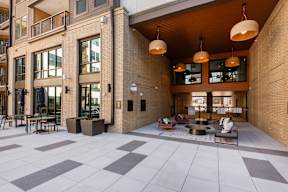 A modern courtyard with a seating area and a glass wall.