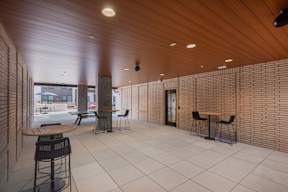 A long hallway with tables and chairs on the side.