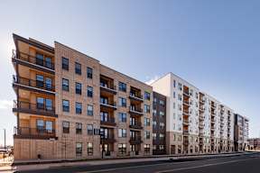 A row of modern apartment buildings with balconies and large windows.