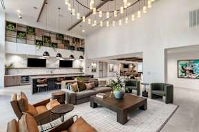 A modern living room with a large sofa, armchairs, and a coffee table.