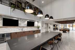 A modern kitchen with a long table and chairs.