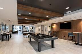 A spacious room with a pool table and a bar area.