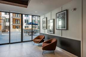Two chairs sit in a room with a view of a patio outside.
