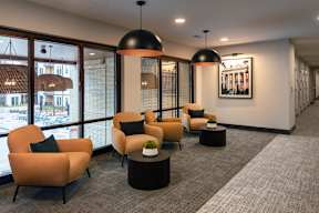 A modern waiting room with orange chairs and a large window.